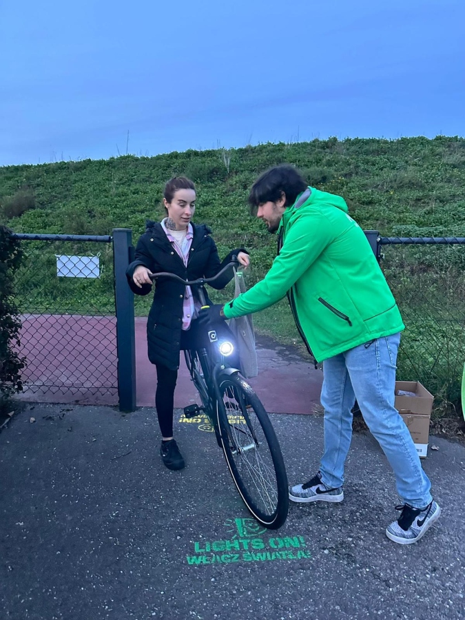 Welfare Officer deelt fietsverlichting uit