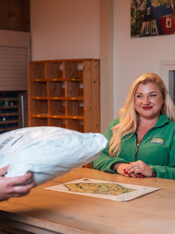 Welfare Officer geeft een pakketje aan een bewoner van KaFra Blitterswijck