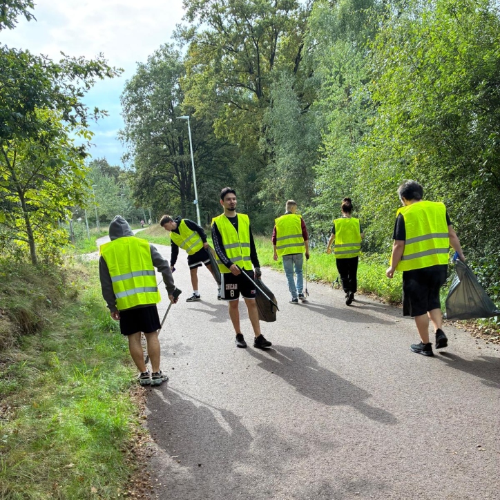 Medewerkers en bewoners van KaFra ruimen zwerfvuil op in het bos